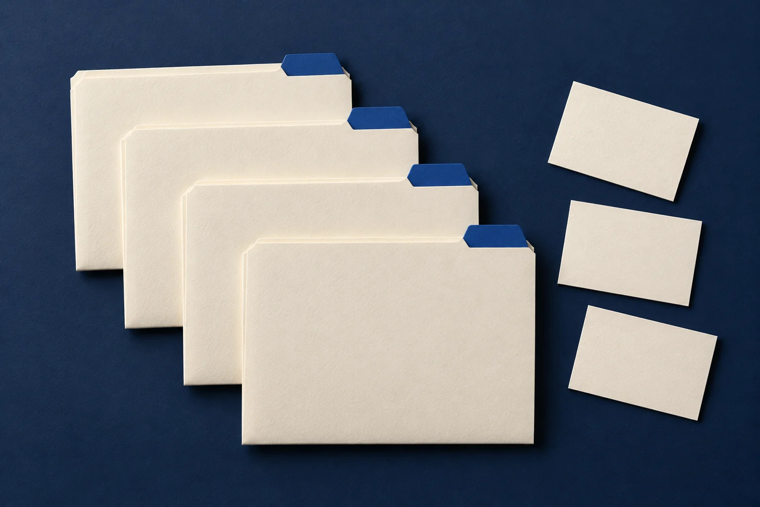 Vier leere Papiermappen mit blauen Registern liegen neben kleinen Karten.