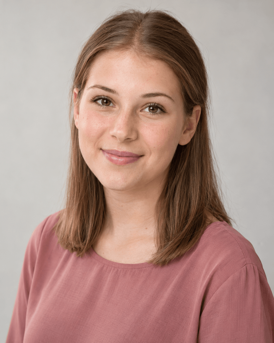 Junge Frau um die siebzehn mit glattem hellbraunem schulterlangem Haar und altrosa Bluse vor einer schlichten hellgrauen Studiowand, offener aufmerksamer Blick