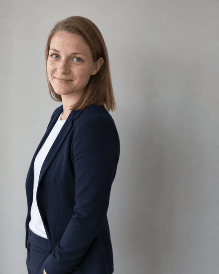 Frau vor einer völlig leeren hellgrauen Wand, ohne harten Schatten hinter ihr