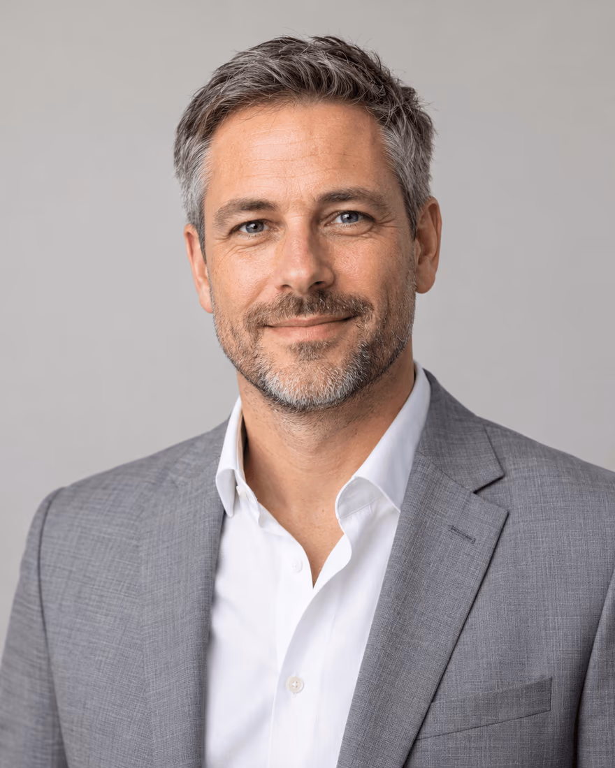 Portrait corporate d’un homme en veste grise sur fond neutre, format vertical pour page équipe