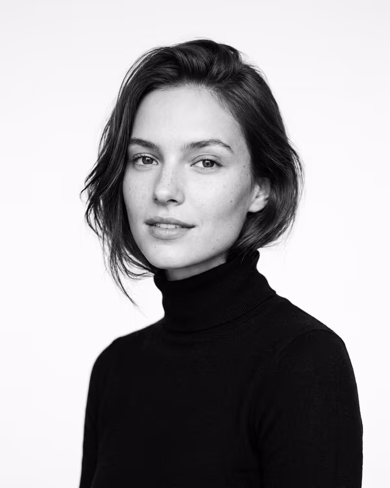 Schwarz-Weiß-Profilbild im Editorial-High-Key-Stil: helles Porträt vor weißem Hintergrund
