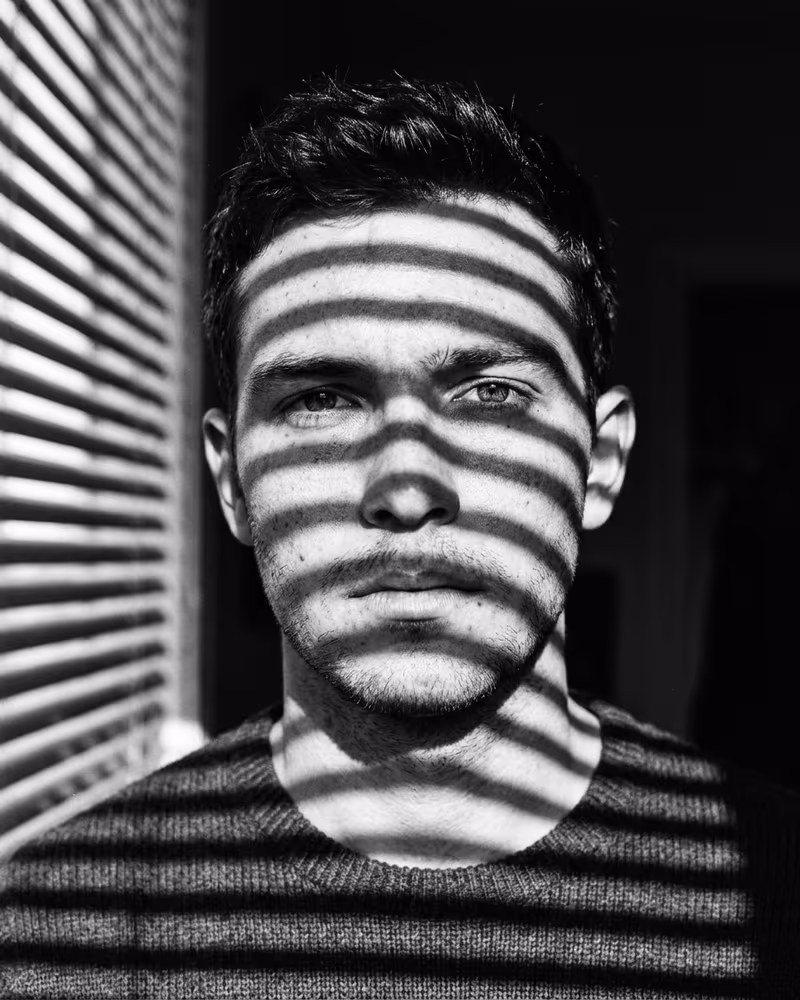 Schwarz-Weiß-Profilbild im Linien-Stil: grafische Lichtstreifen über dem Gesicht