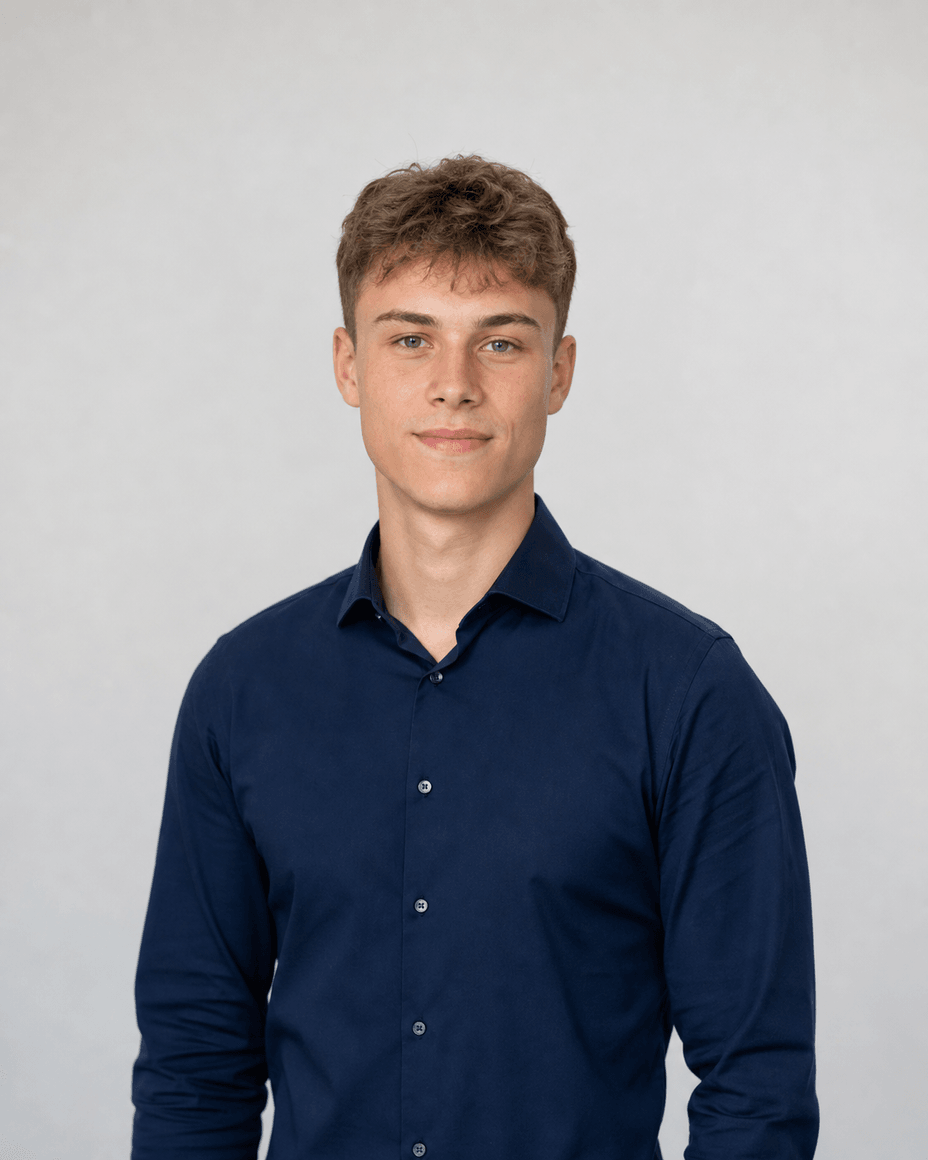 Junger Mann im dunkelblauen Hemd, die gesamte Schulterlinie ist im Bild, über dem Kopf bleibt Luft