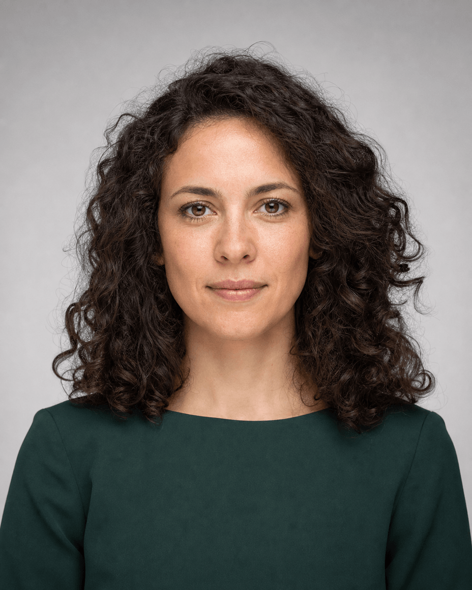 Frau mit dunklen Locken, von vorn beleuchtet, der einzige Schatten liegt weich unter dem Kinn