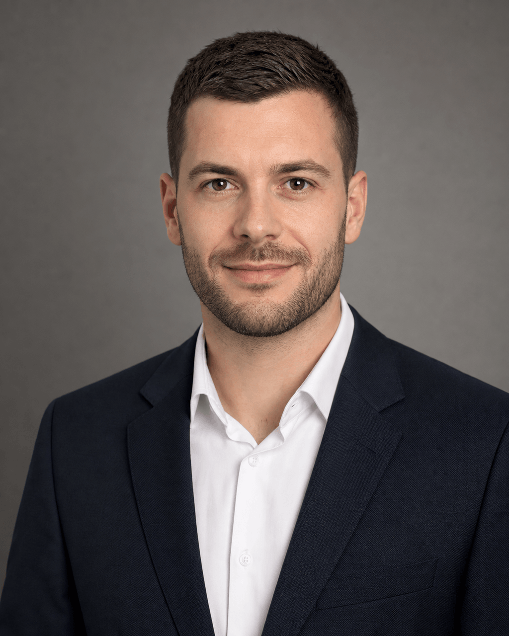 Professional headshot of a man in a dark blue suit