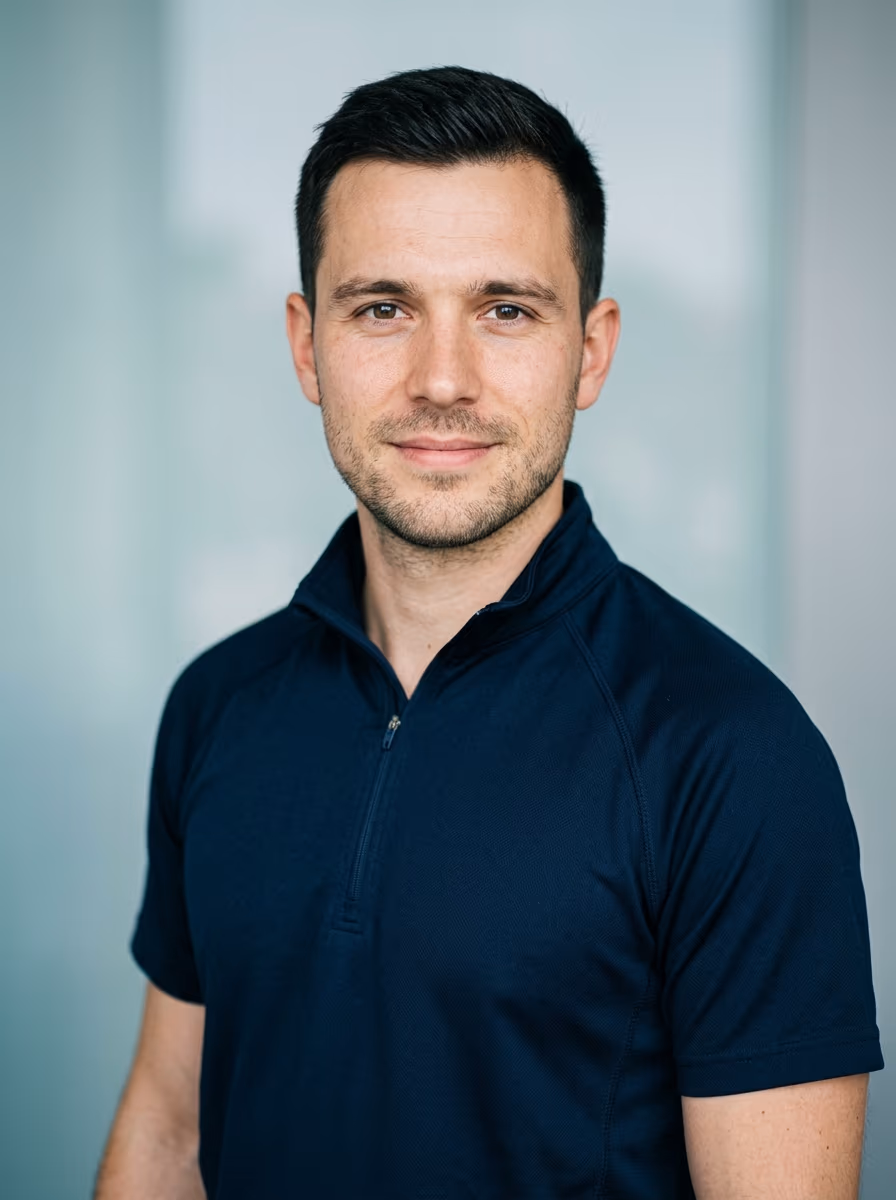 Bewerbungsfoto eines Notfallsanit&auml;ter-Bewerbers mit ruhigem, festem Blick und dunkelblauem Funktionsoberteil vor neutralem Hintergrund
