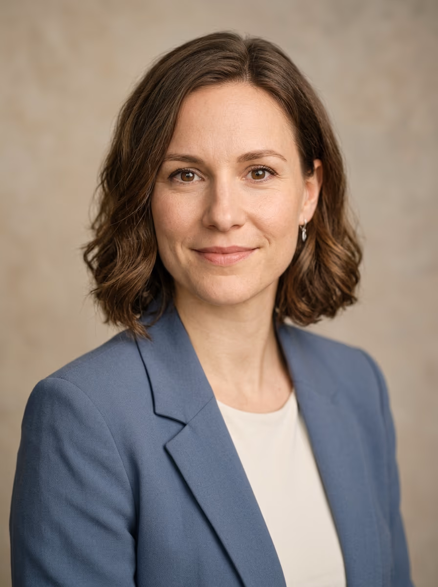 Portrait en buste d’une femme en veste bleue sur fond uni, exemple de photo de CV sobre