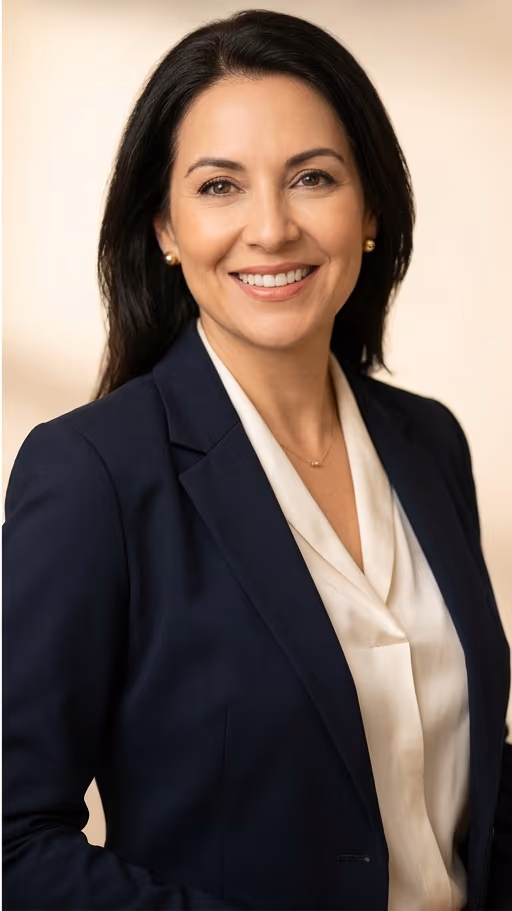 Navy blazer against a warm beige background at 72 pixels; the face fills the upper half of the square