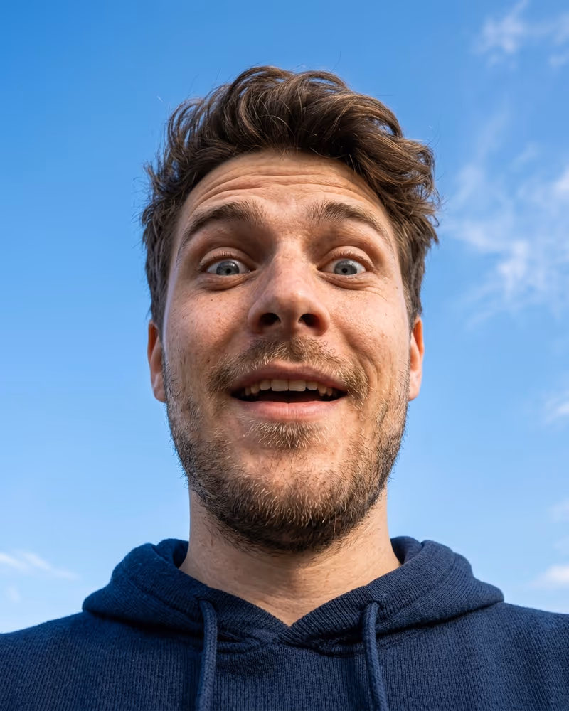Lustiges Profilbild aus der Froschperspektive: Mann schaut überrascht nach unten in die Kamera