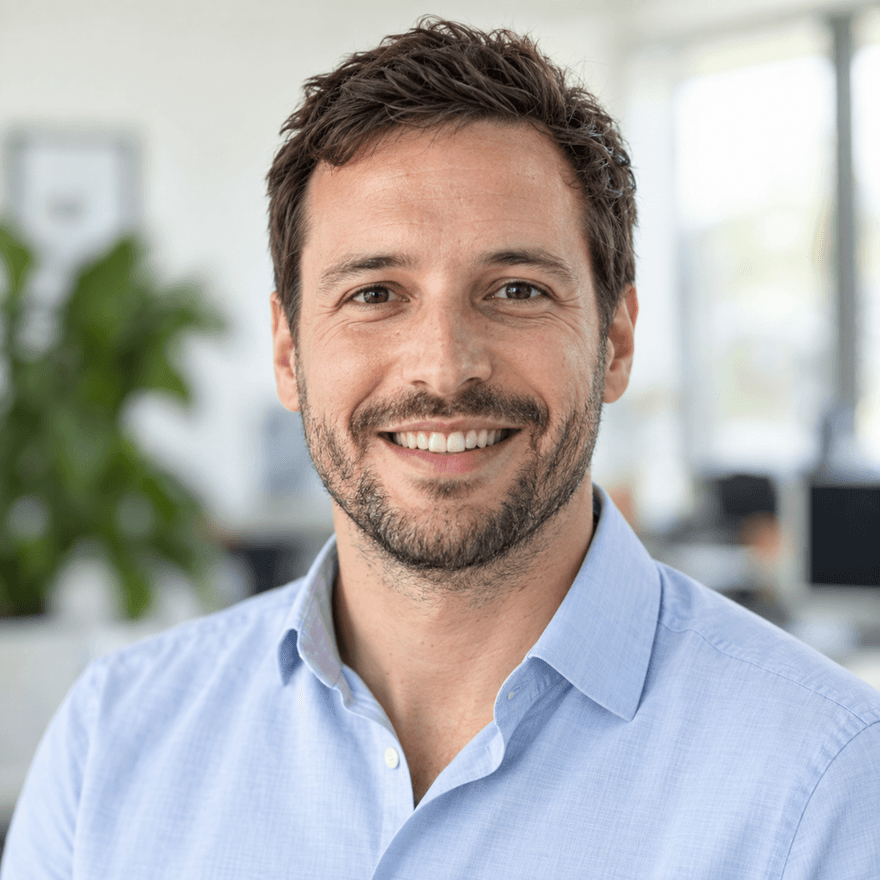 Beispiel im Stil LinkedIn Modern: lächelnder Mann im hellblauen Hemd vor hellem, unscharfem Büro